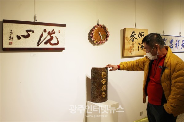 ‘17번째 무진서각회 전통서각전’에서 양웅렬 작가가 등나무 껍질에 '장무상망(長毋相忘)'을 새긴 작품을 설명하고 있다.