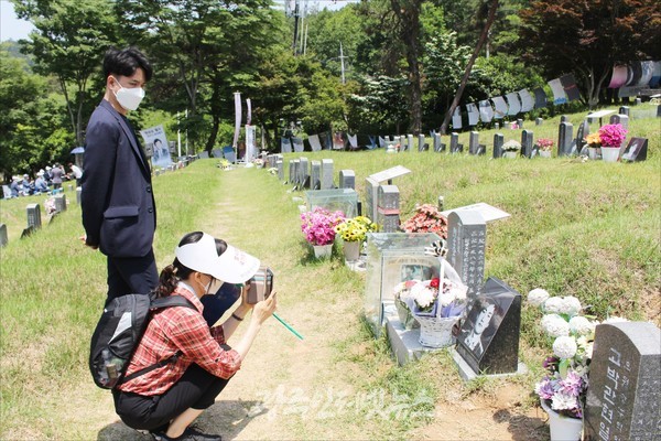 이한열 열사 묘소와 영정사진을 카메라에 담는 모습.