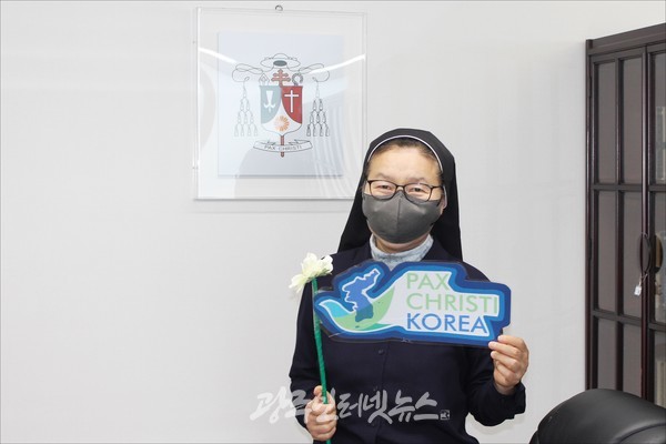 '팍스 크리스티' 문양 앞에서 기념촬영을 하는 PCK 공동대표 이희윤 스텔라 수녀님.