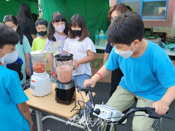 광산구 마지초, ‘푸른 별 지구를 위한 탄소중립, 바로 지금 나부터!' 축제 중 '자전거로 전기 생산해 주스 만들기' 모습.