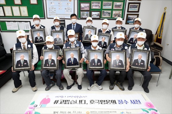 6·25참전유공자회를 방문한 박병규 광산구청장 당선인이 장수사진을 든 회원들과 기념 촬영을 하고 있다.