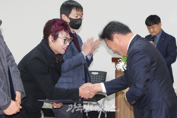 농협 제52기 정기총회에서 기재만 조합장이 김현님 회장에게 마트 이용 우수상을 수상하고 악수로 축하하고 있다.